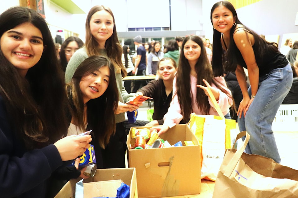 Royal Bay Secondary students sort through some of the items collected during 10,000 Tonight.