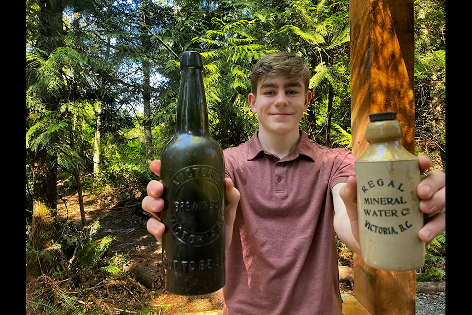 Jack MacMillan with historic bottles he found searching deep in the soil of a West Shore park. 