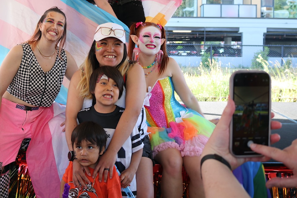 Brittney Sam with her children Matthew (2) and Brayden (6), pose with the drag performers.