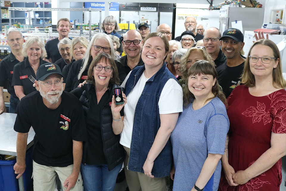 Gayle Ireland celebrates her King Charles III Coronation Medal with food bank volunteers and Langford Couns. Mary Wagner and Kimberley Guiry.