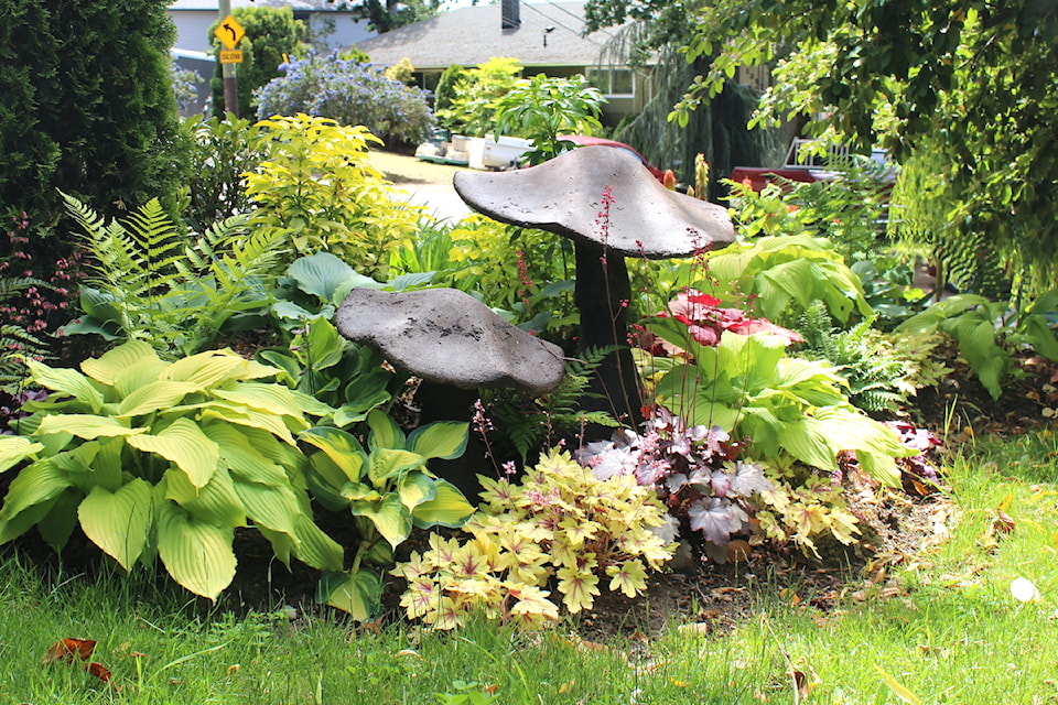 Lush plants surround ornamental mushrooms in the first-place garden.