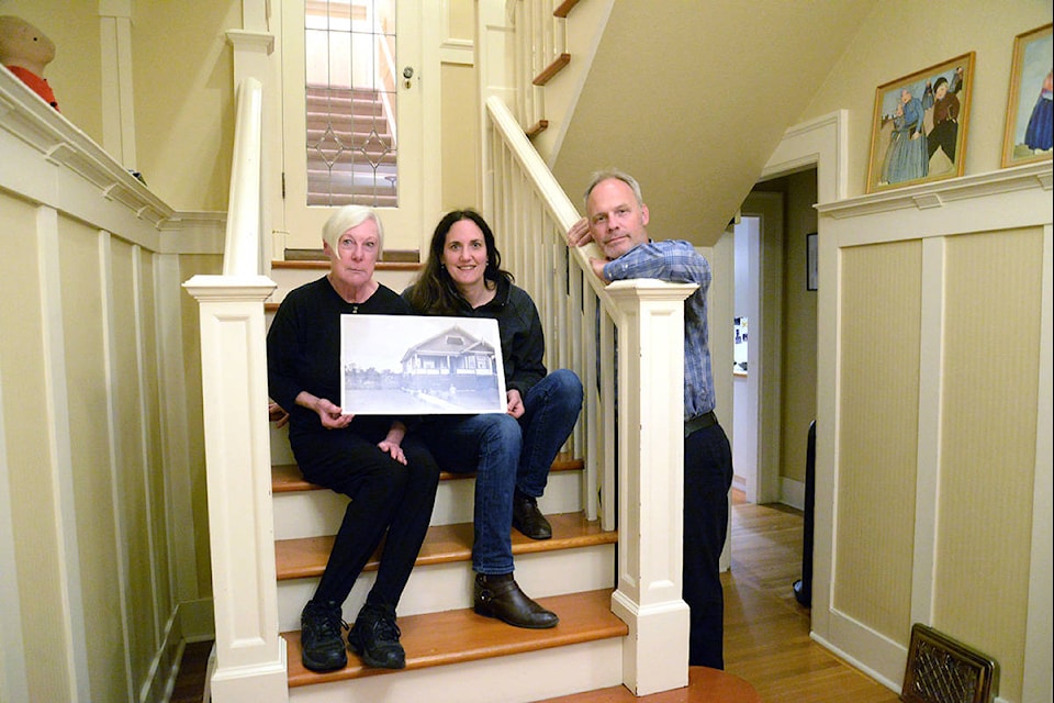 From left to right: Bronwyn Taylor, Claire Miller and Joe Leroy hold an old picture of Taylor’s mother outside the house Miller and Leroy now call home. Taylor hopes more historic properties will be protected in Oak Bay. (Nina Grossman/News Staff)
