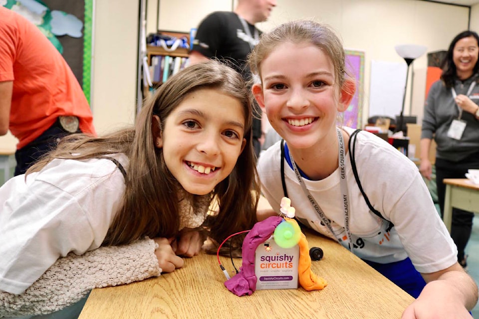Grade 6 students Skye Marley, right, and Sabrina Cain show off their fan that is powered with batteries and playdough. (Aaron Guillen/News Staff)