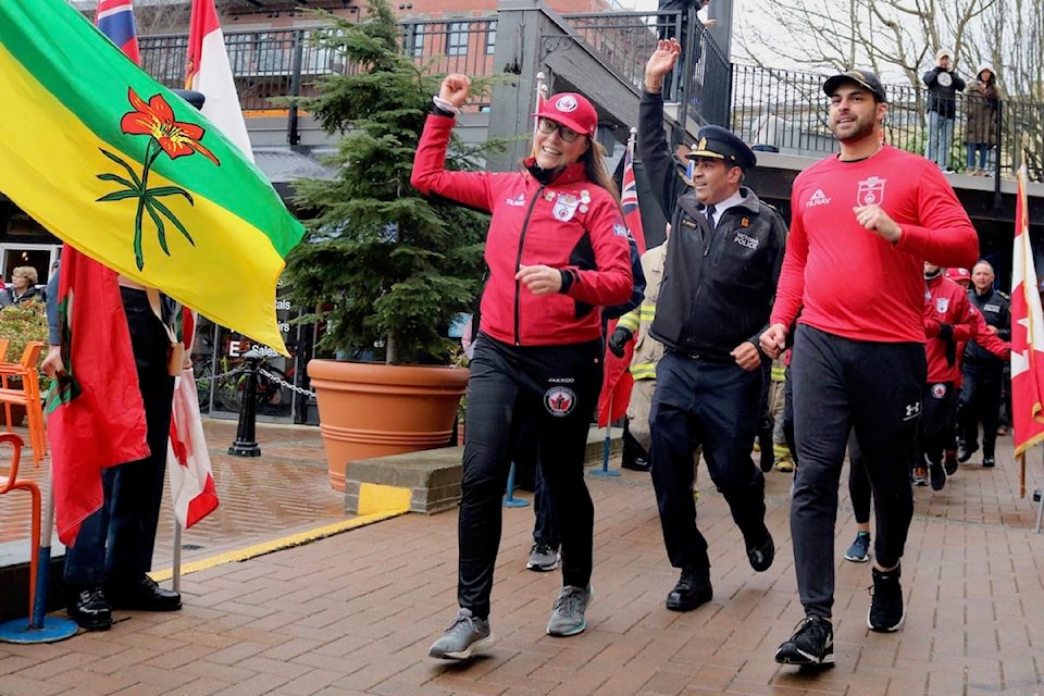 Wounded Warriors B.C. event coordinator Jacqueline Zweng, left, leads the runners on the final approach to the end of their 600 km relay race fundraiser. The program that supports PTSD programs raised over $155,000. (Aaron Guillen/News Staff)
