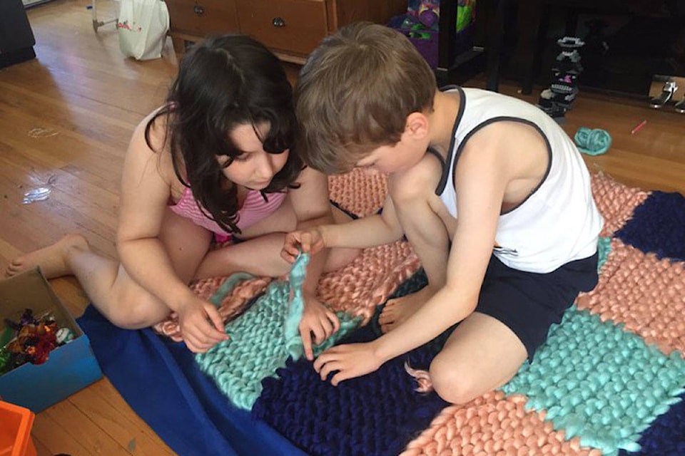 Haley (left) and Jacob Paetkau knit their father a blanket for Easter since they can’t hug him during the pandemic. (Photo courtesy Steve Sxwithul’txw)