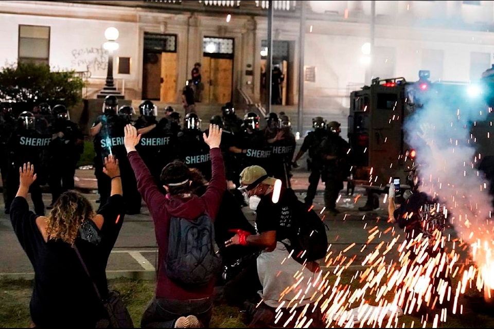 Police attempt to push back protesters outside the Kenosha County Courthouse, late Monday, Aug. 24, 2020, in Kenosha, Wis. Protesters converged on the county courthouse during a second night of clashes after the police shooting of Jacob Blake a day earlier turned Kenosha into the nation’s latest flashpoint city in a summer of racial unrest. (AP Photo/David Goldman)