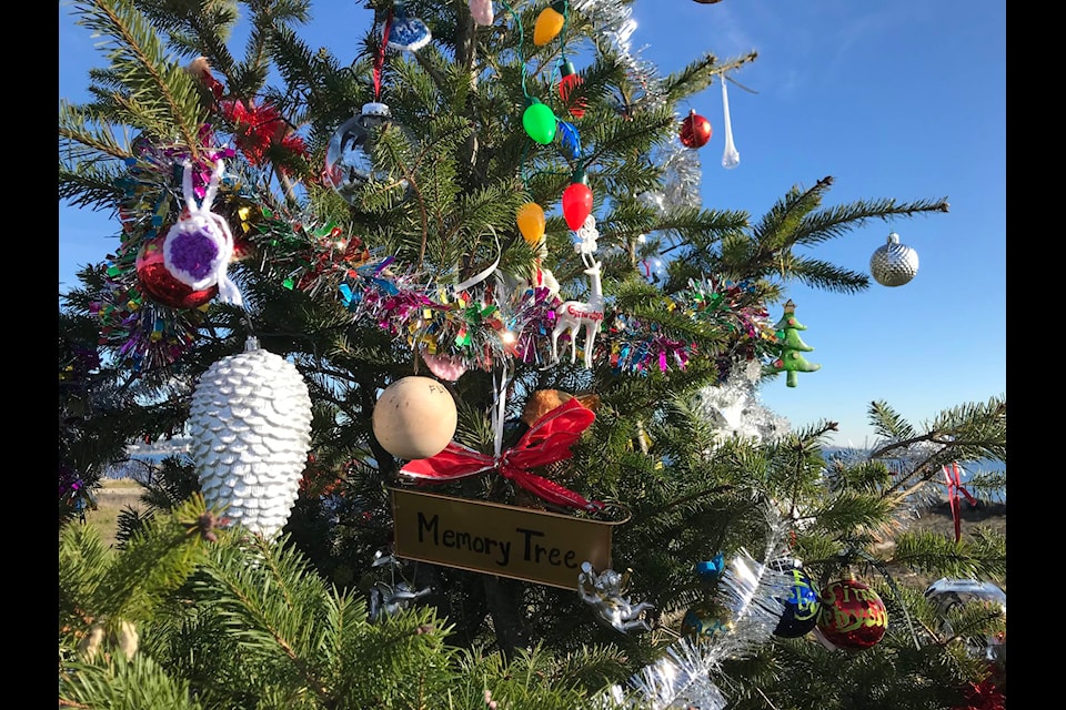 A Christmas tree that mysteriously appeared on Lagoon Road in Colwood is gathering a host of decorations, memories and messages. Many of the ornaments have names on them, and there’s a plaque that pays tribute to the province’s chief medical officer and includes her message to all of ‘be kind, be calm, and be safe.’ (Joan Stiebel/Black Press Media)