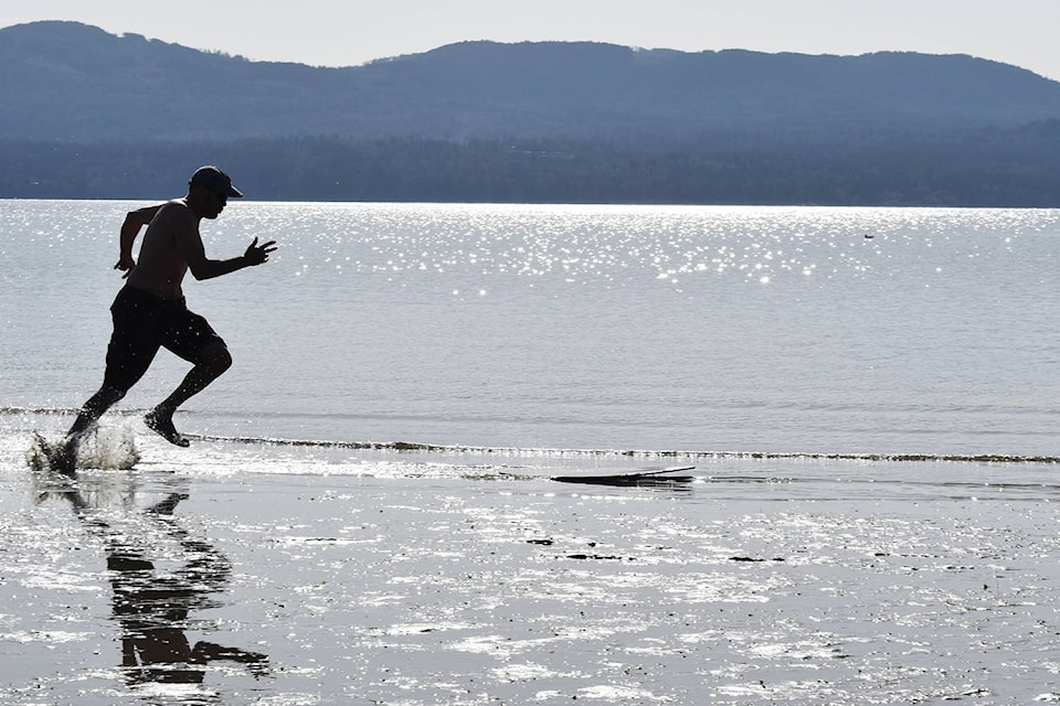 Toby Watson races up to his skimboard Monday afternoon at North Saanich’s Patricia Bay. (Wolf Depner/News Staff)