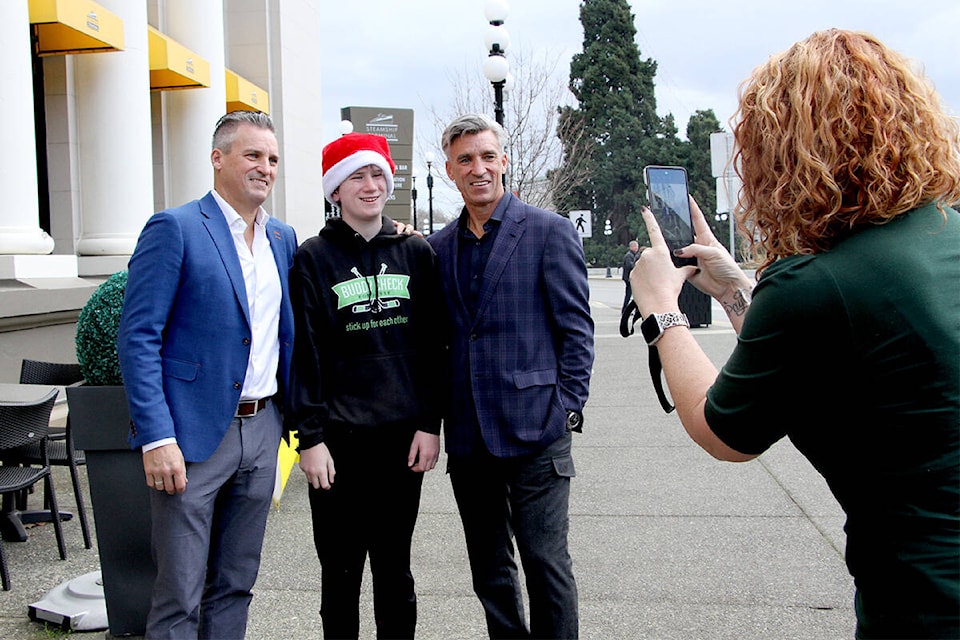 Lindsay Goulet snaps a photo of son Owen, 13, with Bruce Courtnall, left, and Geoff Courtnall during the Victoria launch event for the Courtnall Society of Mental Health. (Christine van Reeuwyk/News Staff)