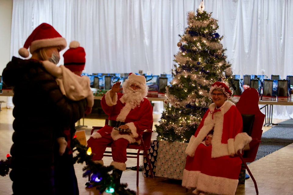 Santa and Mrs. Claus wave to a waiting family Tuesday afternoon at the legion branch in Langford. Volunteers handed out a turkey meal, food and gifts to 73 families. (Justin Samanski-Langille/News Staff)