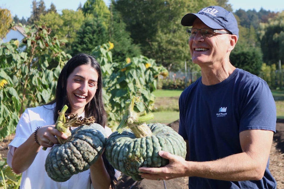 Emily Mulroney, a fourth-year student at Royal Roads, and university president Philip Steenkamp hold squash harvested from the Giving Garden. (Bailey Moreton/News Staff)