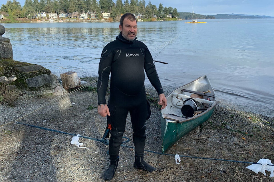 Joe Quin, here seen Wednesday afternoon standing on the shores of Roberts Bay in Sidney, says he hopes to refloat his vessel Thursday morning after it almost completely sank Tuesday morning. (Wolf Depner/News Staff)