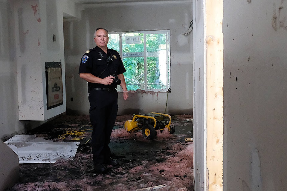 Langford Fire Rescue Assistant Chief Lance Caven stands in the debris of a fire while documenting evidence for an investigation. (Black Press Media file photo)