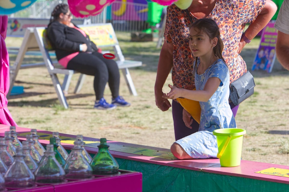 Elayna Romphf tries her hand at the ring toss Thursday, May 18, during the opening evening of the 2023 Luxton Spring Fair in Langford. (Justin Samanski-Langille/News Staff)