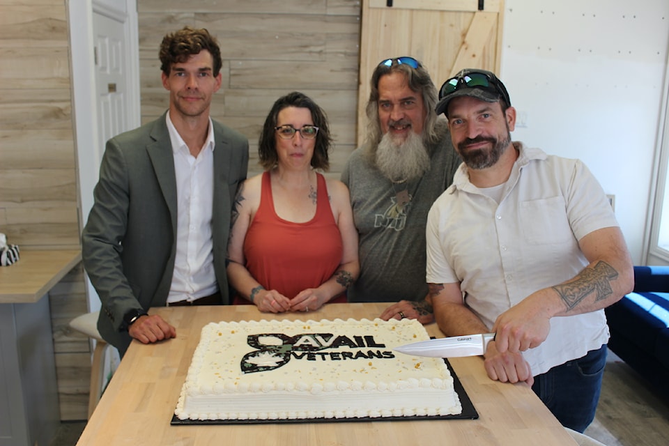 Veteran Adam Cyr cuts the celebratory cake at the grand opening of Avail Veterans Clinic, supported by Justin Whitehall, Megan Laker and veteran Rick Laker.