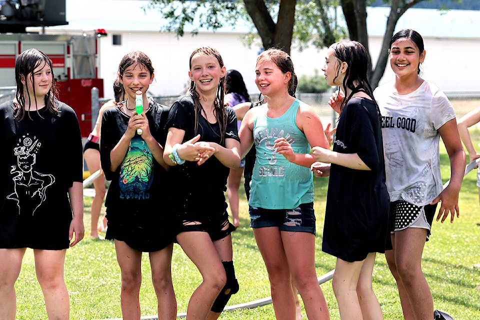 From the left: Hutton Elementary’s Emily Williamson, Larrissa Tubrett, Kali Romaine, Peyton Greyson, Kaydee Thiessen and Harjot Kherha dry off after half an hour under Grand Forks Fire/Rescue’s water cannon. Photo: Laurie Tritschler