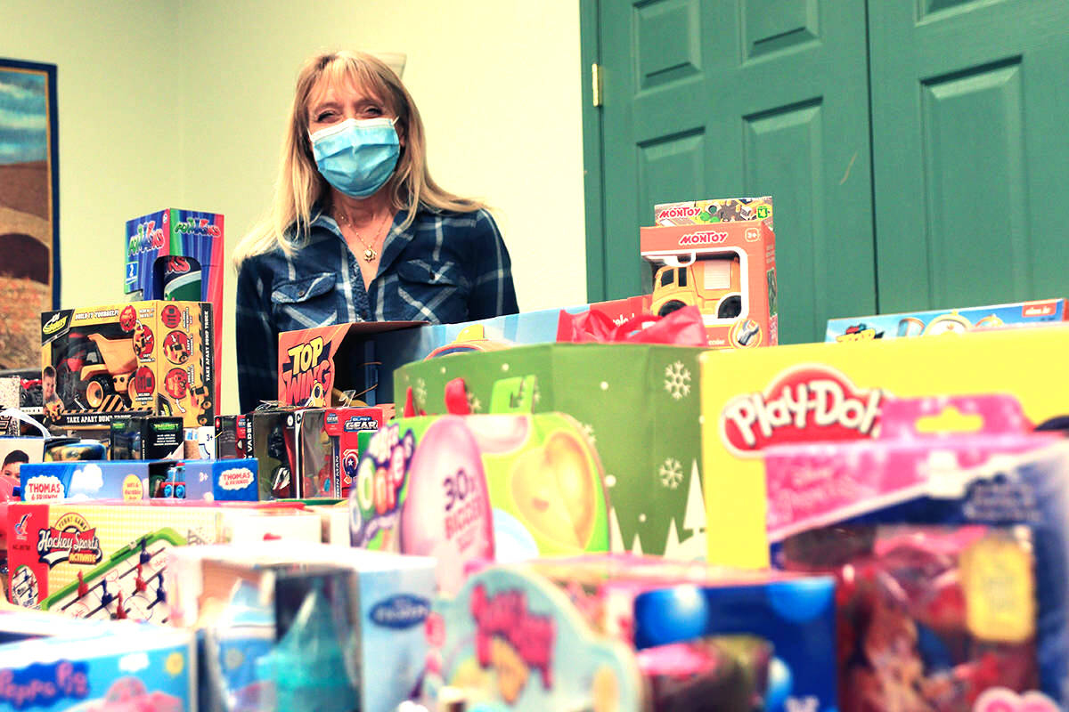Volunteer Debbie Fehr stands over a table spread end to end with donated toys at Grand Forks Gospel Chapel Dec. 16, 2020. Toys were collected by staff at Grand Forks Realty, Grand Forks Credit Union and Save-On Foods. Photo: Laurie Tritschler