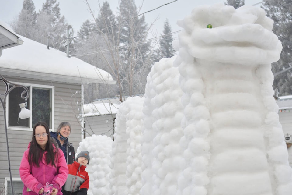 An excited school bus driver with two of her young passengers made a pit stop at 771 Vaughan Street on Wednesday, Jan. 26 for a photo with Vanessa Hildreth’s “Snowgopogo 2022’ sculpture. (Rebecca Dyok photo)