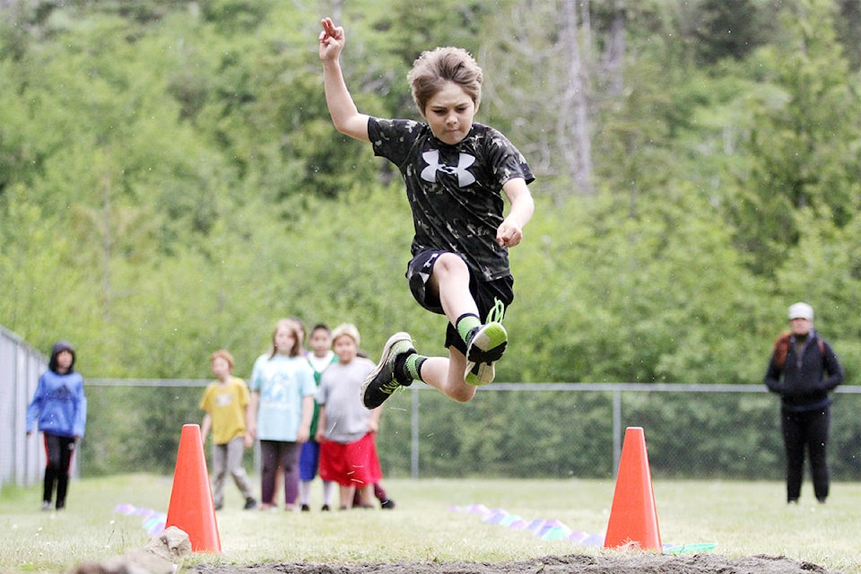 Tyler Collison leaps into a long jump at the all-islands Track and Field Day held at Sk’aadgaa Naay Elementary on Thursday, June 7. (Andrew Hudson/Haida Gwaii Observer)