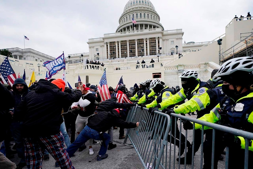 FILE - In this Wednesday, Jan. 6, 2021 file photo, Trump supporters try to break through a police barrier at the Capitol in Washington. Right-wing extremism has previously mostly played out in isolated pockets of America or in smaller cities. In contrast, the deadly attack by rioters on the U.S. Capitol targeted the very heart of government. It brought together members of disparate groups, creating the opportunity for extremists to establish links with each other. (AP Photo/Julio Cortez, File)