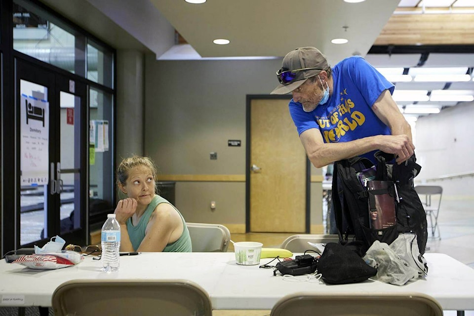 Rory Lidster, 55, right, and Amanda Marshall, 41, unpack after checking into a cooling center in Portland, Ore., Tuesday, July 26, 2022. Temperatures are expected to top 100 degrees F (37.8 C) on Tuesday and wide swaths of western Oregon and Washington are predicted to be well above historic averages throughout the week. “I don’t know how long they’re going to be doing this, but I hope it’s for a little while. As long as we can be, I will be here,” Lidster said. (AP Photo/Craig Mitchelldyer)