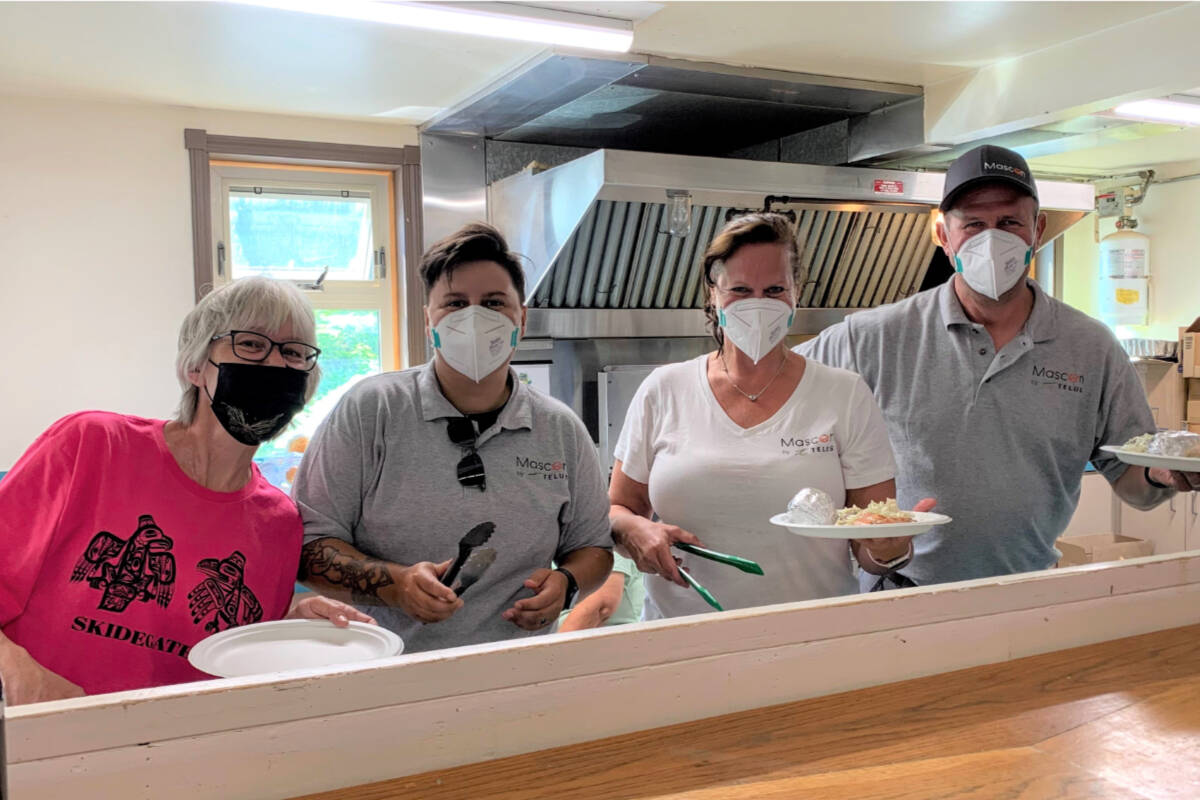 Mascon by TELUS team members help serve up a salmon dinner in celebration of Skidegate Days. Photo supplied