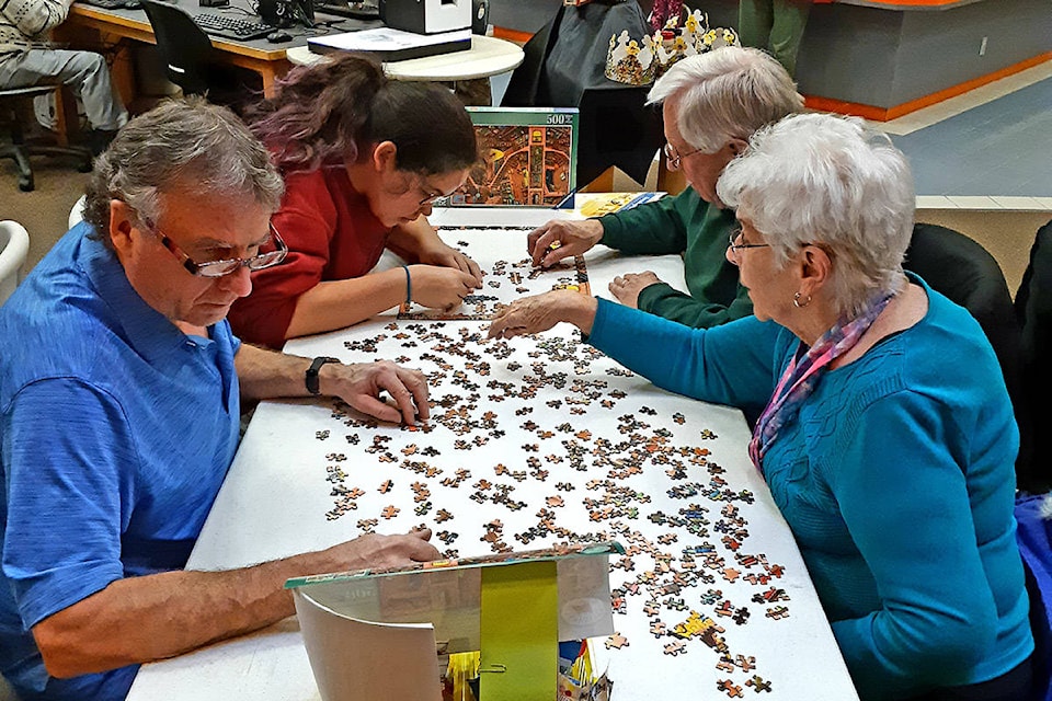 Ray Daws, Pat Daws, Don Wiens, and Neela Gladue work at their puzzle at the Hope Library on Jan. 11. (Chris Duchaine/ Black Press)