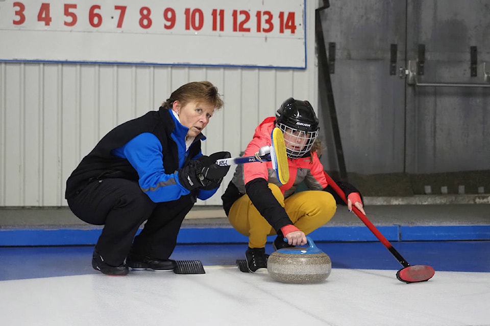 Long-time Hope Curling Club member, Deb McKinney helps Nyah Thiessen plan her shot during a junior curling session at the Hope Curling Club. The session was part of a school program introducing middle school students to the sport. (Barry Stewart/ Hope Standard)