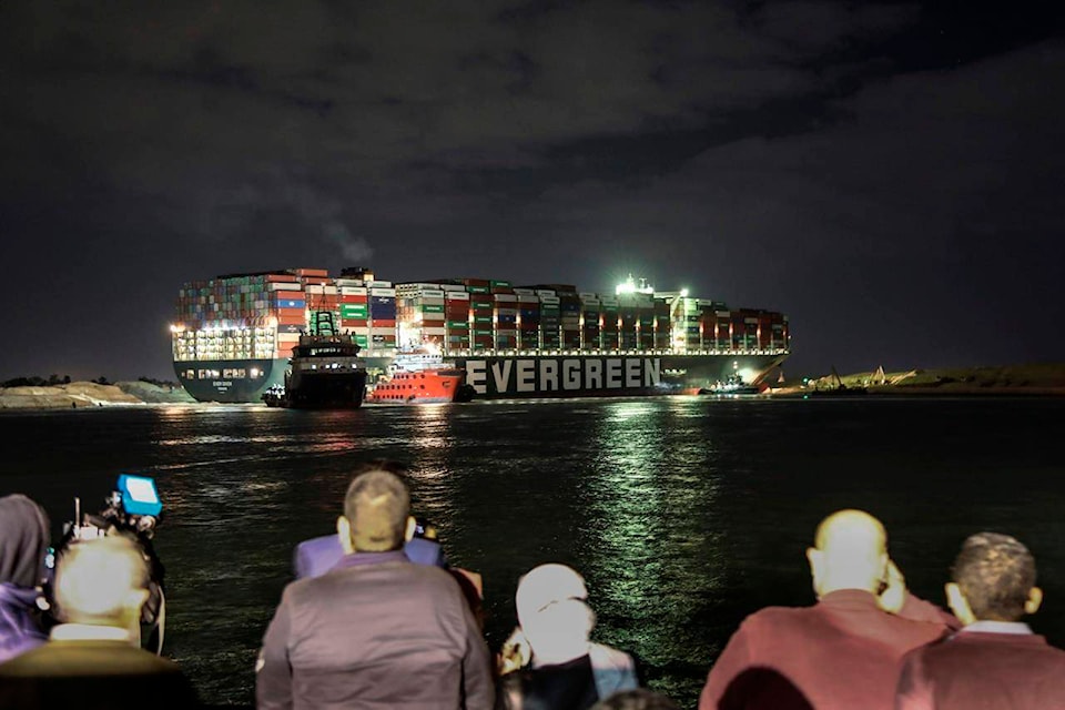 Ever Given, a Panama-flagged cargo ship, that is wedged across the Suez Canal and blocking traffic in the vital waterway is seen Saturday, March 27, 2021. Tugboats and a specialized suction dredger worked to dislodge a giant container ship that has been stuck sideways in Egypt’s Suez Canal for the past three days, blocking a crucial waterway for global shipping. (AP Photo/Mohamed Elshahed)