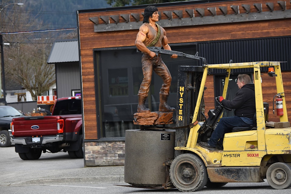 Communities in Bloom volunteer Victor Smith escorts the Rambo statue down Wallace Street on April 1. (Photo/Adam Louis)