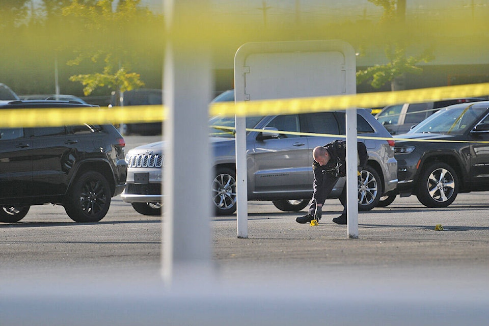 An RCMP officer places evidence markers in the parking lot of O’Connor Chrysler on Friday, Sept. 24, 2021. (Jenna Hauck/ Chilliwack Progress)