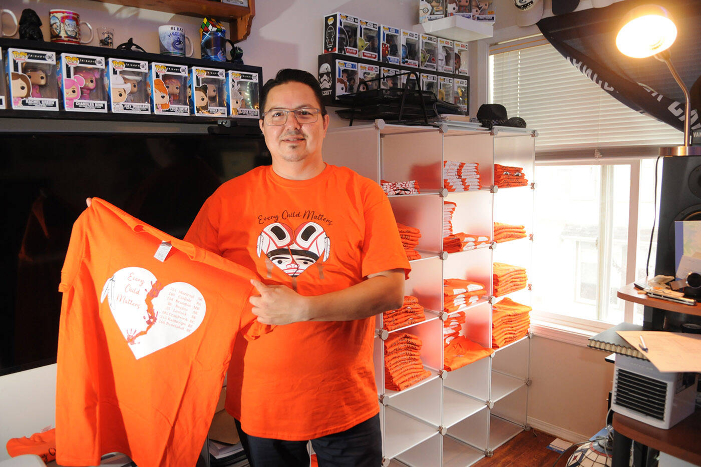 Shawn E. Baginski has been selling orange shirts he designed with all proceeds going to survivors of residential schools. He is pictured here in his Chilliwack home on Sept. 28, 2021. (Jenna Hauck/ Chilliwack Progress)