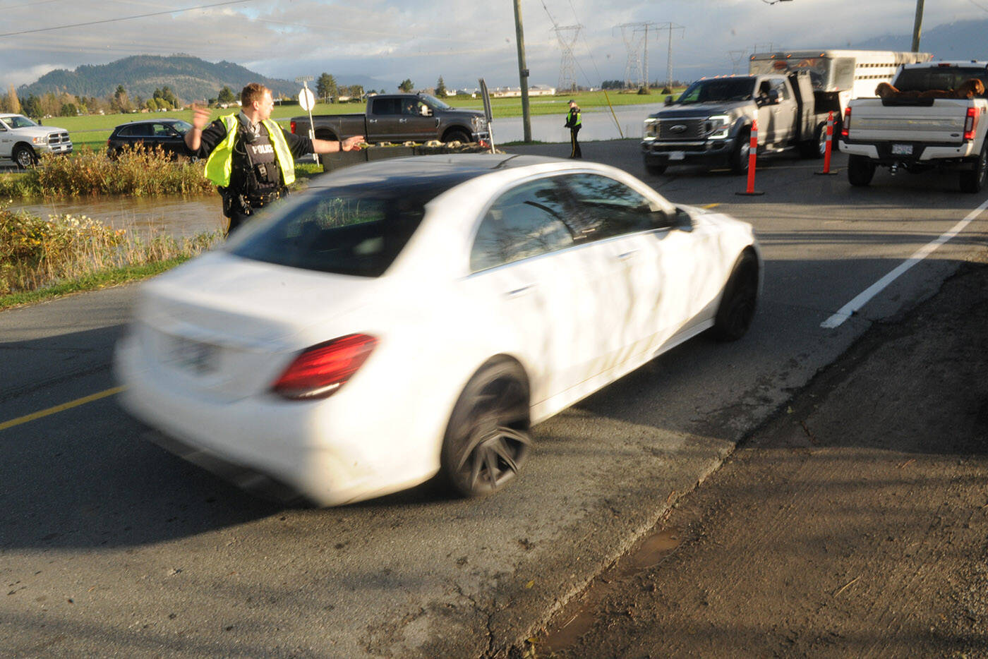 RCMP officers control traffic on the east side of the Keith Wilson Bridge at Chadsey Road as folks from Sumas Prairie and Yarrow leave the area following an evacuation order on the morning of Tuesday, Nov. 16, 2021. (Jenna Hauck/ Chilliwack Progress)