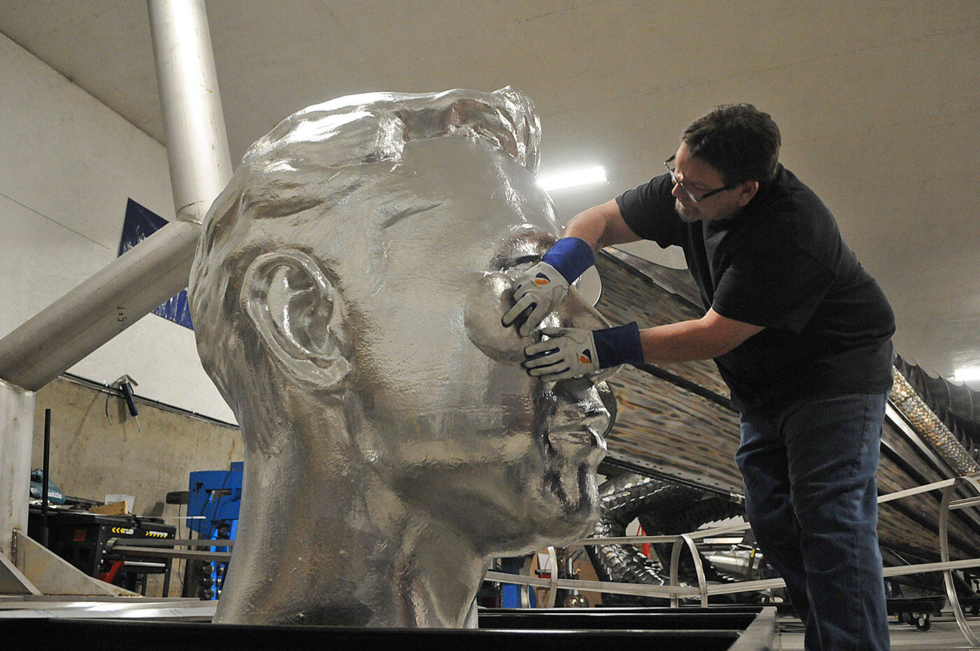 Chilliwack sculptor Kevin Stone fits pieces of aluminum to a gigantic Elon Musk head in his workshop on Tuesday, Jan. 18, 2022. (Jenna Hauck/ Chilliwack Progress)