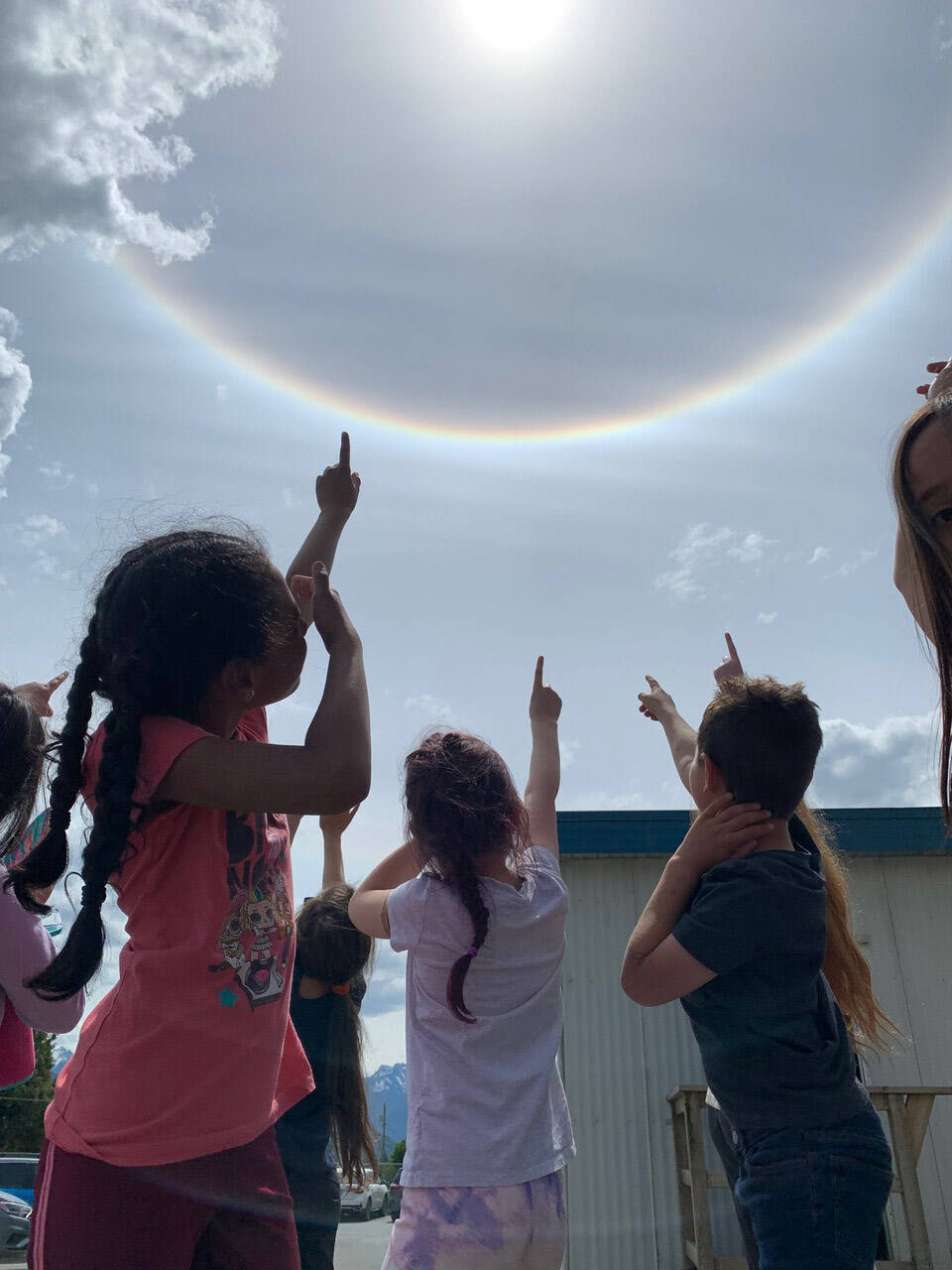 Grade 1 and 2 students from Cheam Elementary point to a sun halo in Chilliwack on Wednesday, June 1, 2022. (Monica Little)