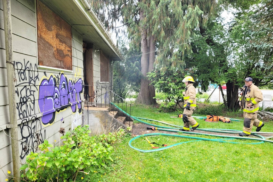 Firefighters attend to a fire isolated to the outside of a house in Maple Ridge on Tuesday, June 21. (Neil Corbett/The News)