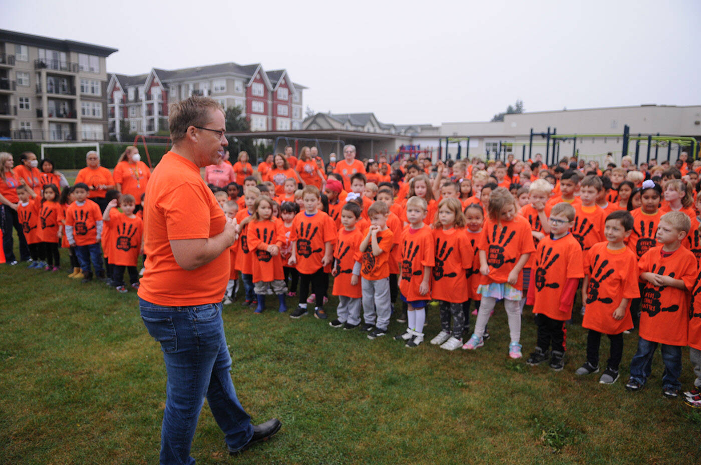 Bernard Elementary principal Brad Johnston speaks to students as they gather for a group photo outside the school on Thursday, Sept. 29, 2022. The schools parent advisory council bought an orange T-shirt for every single student at Bernard. (Jenna Hauck/ Chilliwack Progress)