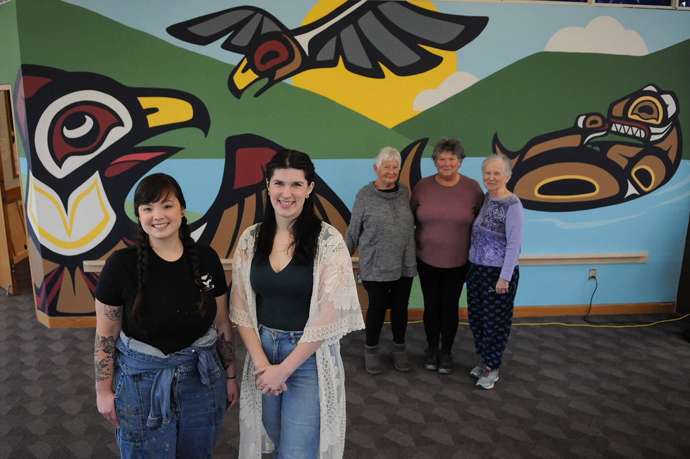 From left, artist Chantelle Trainor-Matties, librarian Kelli Whitehead and members of Friends of the Chilliwack Libraries group Roberta Roxburgh, Terry Hildebrant and Claire Bouchard stand in front of a mural at the Chilliwack Library on Nov. 8, 2022. (Jenna Hauck/ Chilliwack Progress)