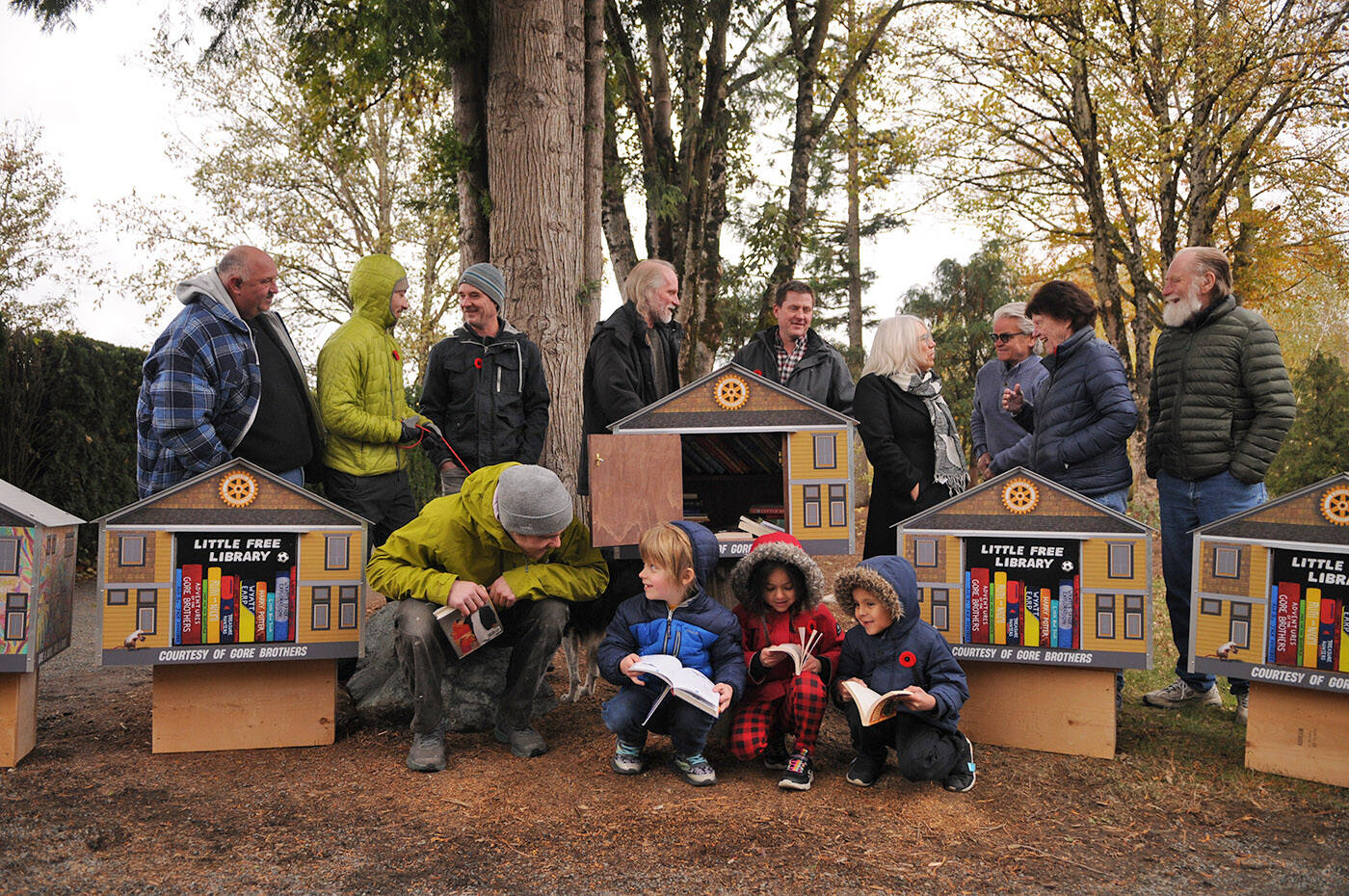 The five book houses with murals on them were unveiled at Fairfield Park in Chilliwack on Thursday, Nov. 10, 2022. Front row (from left): Chilliwack artist Jack Hendsbee, six-year-old Jack Gore, five-year-old Naomi Gore and seven-year-old Wyatt Gore were all part of the project. (Jenna Hauck/ Chilliwack Progress)