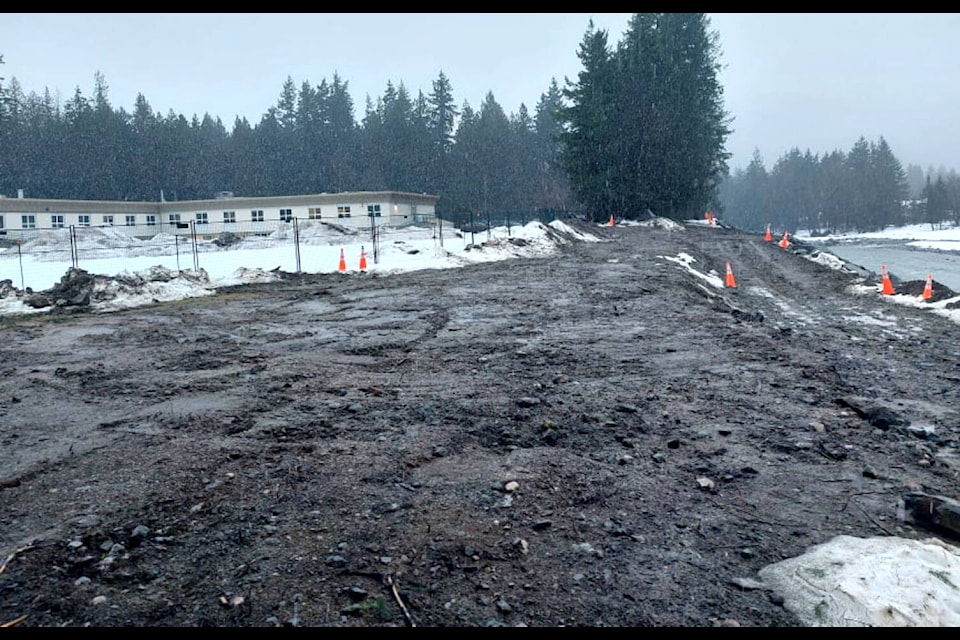 Crews have been at work building up protection to keep Fraser Canyon Hospital (left) safe from the surging flood waters of the Coquihalla River (right). (Eric J. Welsh/ Hope Standard)