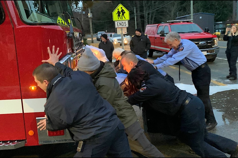 About a dozen Harrison firefighters push the brand-new engine into the bay during a push-in ceremony held Friday, Jan. 6 (Adam Louis/Observer)