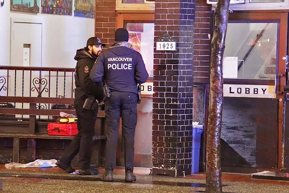 Vancouver police officers examine the scene outside a former Hostelling International site on Granville Street, where a 32-year-old was shot and critically injured Jan. 17. (Credit: Shane MacKichan/ Special to Black Press Media)