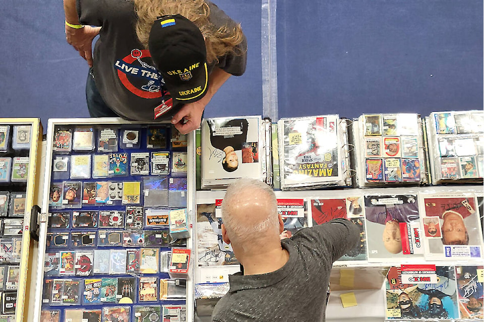 Steven Panet (bottom) talks to a fellow vendor at the Western Canada Collectibles Experience at Langley Events Centre on Sunday, April 9. Panet, who owns Fastball Collectibles, came in from Ontario to attend the three-day event. (Dan Ferguson/Langley Advance Times)