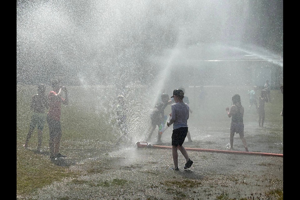 Families ran through sprinklers in the Harrison Hot Springs Fire Department’s impromptu water park near Harrison Elementary late last week. (Adam Louis/Observer)