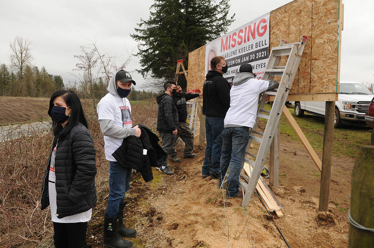 Alina Durham (left) looks out to Highway 1 as drivers honk while behind her, friends and family members help hang a banner with her daughters face on it. Shaelene Keeler Bell of Chilliwack was last seen on Jan. 30, 2021. (Jenna Hauck/ Chilliwack Progress)