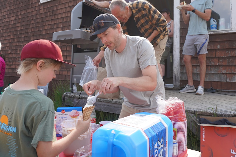 Andrew L'Orsa, chair of the Driftwood Schoolhouse Committee serves scoops of ice cream during a celebration of the Driftwood Schoolhouse on June 21.