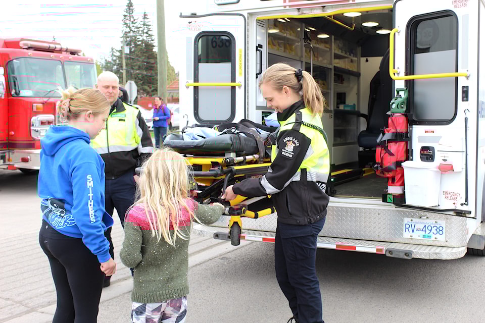 A paramedic shows a group of girls the inside of an ambulance.