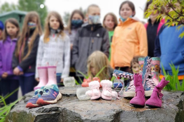 Students from Muheim Memorial Elementary School place shoes at a Smithers Art Gallery memorial to deceased residential school children May 31. (Shannon Goodhead photo)