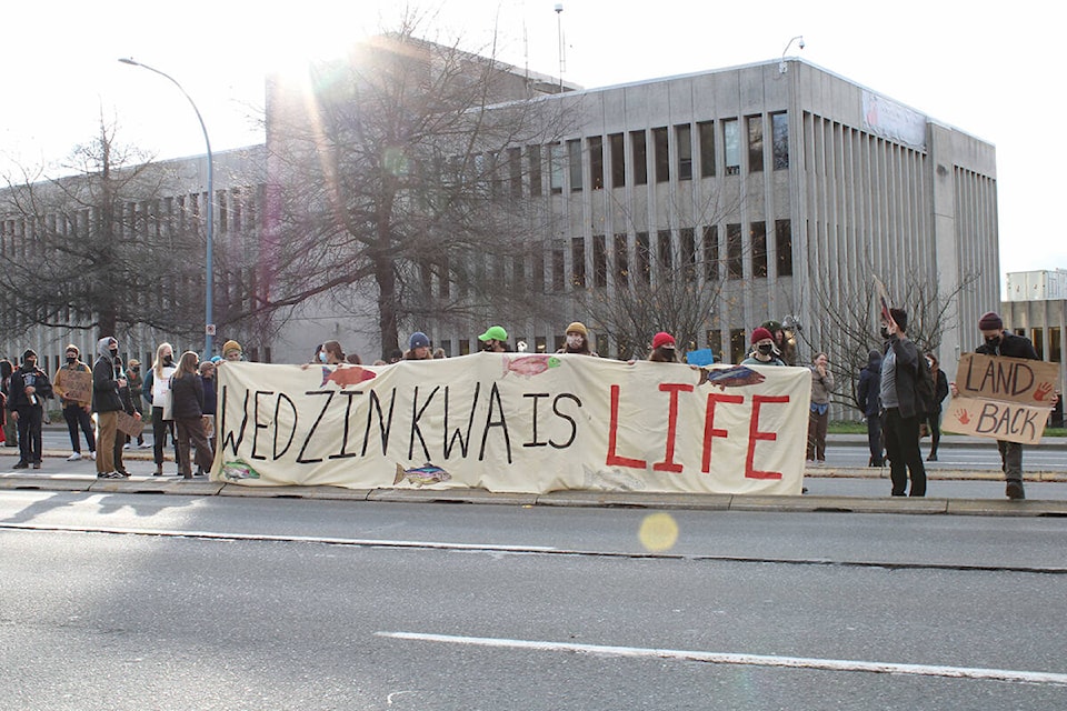 Wet’suwet’en solidarity demonstrators stand outside of RCMP headquarters in Victoria. (Jake Romphf/News Staff)