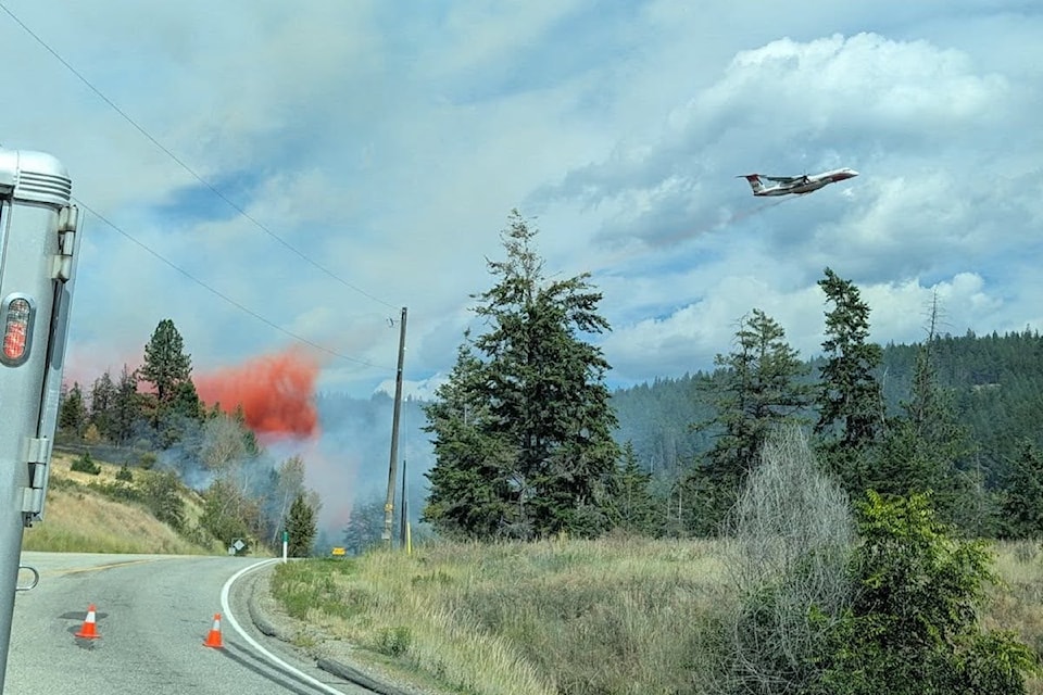 A plane drops retardant on a wildfire just off Highway 33, east of Kelowna, on Aug. 10, 2025. 